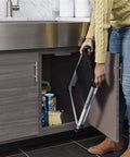 Person storing Totally Handy Lightweight Steel Step Stool With One-Handed Fold under a kitchen cabinet.