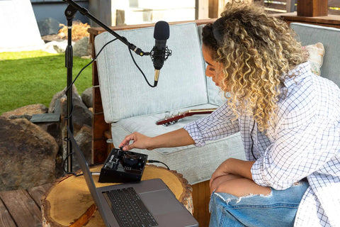 Person using USB-C Audio Interface Kit With 2 In 2 Out, Nova Black Condenser Microphone, Shock Mount, XLR Cable, And HD Headphones