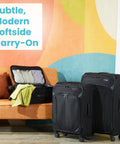Black lightweight spinner carry-on luggage next to a sofa, showcasing modern design and softside expandability.