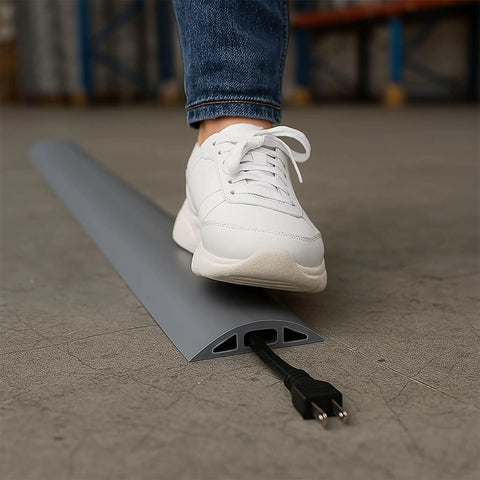 Person stepping on D-2 Rubber Duct Cord Cover 36 Inch Gray Floor Cable Protector for power cables ethernet coax phone lines and more.