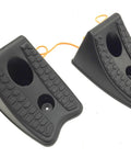Angled view of a pair of black heavy-duty wheel chocks with hex-pattern grip and two holes, linked by orange cords.