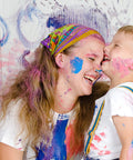 Mother and child laughing with paint splatters on them after using Heavy Duty Cleaning Wipes 260 Count Bulk Pack With Dual Texture For Hands And Surfaces Remove Paint Adhesives Oils Grease And Dirt Grime Busting Safe On Skin With Aloe Vera And Vitamin E.