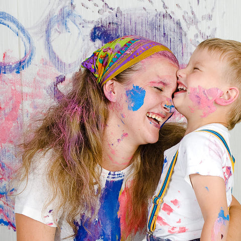 Mother and child laughing with paint splatters on them after using Heavy Duty Cleaning Wipes 260 Count Bulk Pack With Dual Texture For Hands And Surfaces Remove Paint Adhesives Oils Grease And Dirt Grime Busting Safe On Skin With Aloe Vera And Vitamin E.