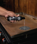 Griddle Top Restoration Kit Includes 8 Oz Griddle Top Restorer And Two Heavy Duty Scrub Pads For Quick Griddle Cleanup And Easy Maintenance On Griddle Plates Side Shelves Cookware And Tools. Hand applying restorer to a griddle plate.