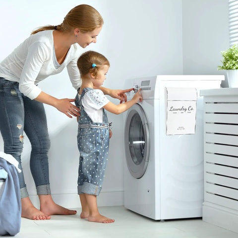 Woman and child doing laundry next to Dual Lint Bin Set For Laundry Room Wall Mounted Space Saving Dryer Sheets Holder