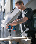 Badass 18V Cordless Drill Driver With Brushless Motor And Smooth Shifting Dual Speed For Tearing Through Tasks Without A Sweat Light Workhorse Power Tool With Grippy Keyless Chuck in use on wood project outdoors.