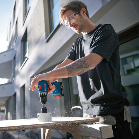 Badass 18V Cordless Drill Driver With Brushless Motor And Smooth Shifting Dual Speed For Tearing Through Tasks Without A Sweat Light Workhorse Power Tool With Grippy Keyless Chuck in use on wood project outdoors.
