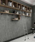 A modern interior with wooden shelves, ladder, and decorative items on a concrete wall
