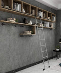 Heavy Duty Black Sliding Ladder Library Hardware With Rollers And Slick Steel Track Kit For Smooth Barn Door Glide Adjustable Rolling Rail Set Easy Install Bundle Without Ladder Included against a grey wall with shelves and books.