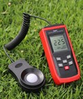 Easy-Read Pro-Grade Digital Lux Meter For Photography And Studio Lighting, Measures 0 To 200000 Lux (Lux/FC) With Clear Readout, Ideal For Photo Shoots, Office, Lab, Stage, And Horticulture Lighting Control, red handheld meter on grass