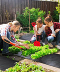 Heavy Duty Weed Barrier Fabric 3.2oz Landscape Material for Garden Beds and Driveways in use with people gardening.