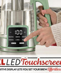 Person using Electric Glass Kettle With 1.7L Capacity, Programmable Tea And Coffee Brewer, Digital Touch Display, Green