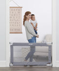 Woman smiling standing with child behind Extra Wide Mesh Baby Gate For Doorways And Hallways Expands From 27.5 To 50 Inches 28 Inches Tall