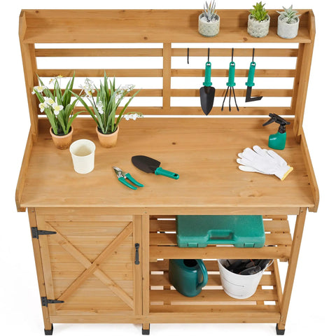 Large Outdoor Potting Bench With Storage Cabinet And Shelf Planting Console For Patio Lawn Garden Pro Grade Fir Wood Workstation Built To Last Durable Finish And Easy Assembly with tools and plants visible.