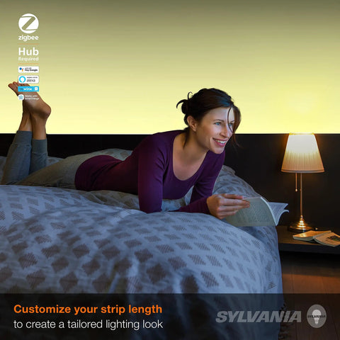 Woman reading in bed with ZigBee RGBW Flex Strip Starter Kit for smart home lighting, tunable white and full color visible.