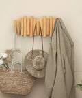 Foldable Wall Coat Rack With Five Hidden Hooks, Modern Wooden Wall Mount Coat Hanger holding bag, hat, and coat in entryway.