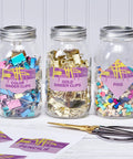 Three glass jars filled with colorful binder clips and pins, labeled Color Binder Clips, Gold Binder Clips, and Pins.