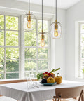 Pendant Lights Kitchen Island, Hand-Blown Clear Glass Brass Gold 9 Inch H hanging above a modern dining table with fresh fruits.