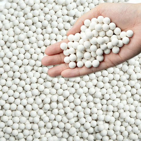 Hand holding 8 Pound Ceramic Tumbling Media Balls For Rock Tumblers Reusable White Alumina Pellets Three Tenths Inch Diameter