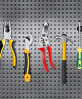 Assorted hand tools including pliers, wrenches, shears, hammer, and screwdriver on perforated metal background.