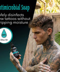 Man with tattoos using Antimicrobial Soap from Tattoo Aftercare Kit 3 Piece Set With Antimicrobial Soap, Tattoo Balm, And Healing Lotion For Fresh Ink, Color Preservation, And Ongoing Ink Maintenance Plus Piercing Care