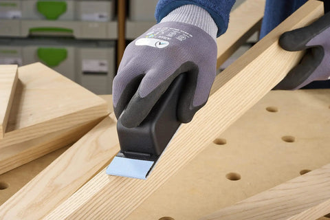 Pocket StickFix Hand Sanding Block with Quick Change Hook and Loop system used on wood, compact grip held by gloved hand.