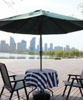 Outdoor Round Tablecloth 60 Inch With Zipper Umbrella Hole Water Resistant Polyester Durable Patio Garden Table Cover in black, installed on a table under a green umbrella with chairs, cityscape background.