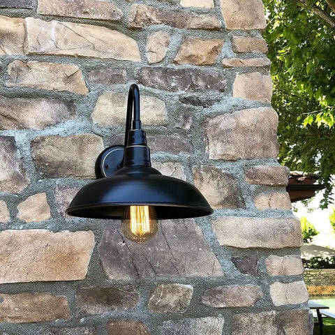 One Light Outdoor Wall Lamp With Metal Shade In Imperial Black Dimmable 120V 60W E26 Base Durable Weather Resistant Outdoor Lighting Fixture For Porch Patio Or Entry Classic Industrial Style Dope Look mounted on stone wall.