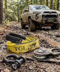 3 Inch Wide 8 Foot Tree Saver Strap With Loops Heavy Duty Winch And Recovery Tow Strap 30000 Lbs MBS in muddy forest with Jeep