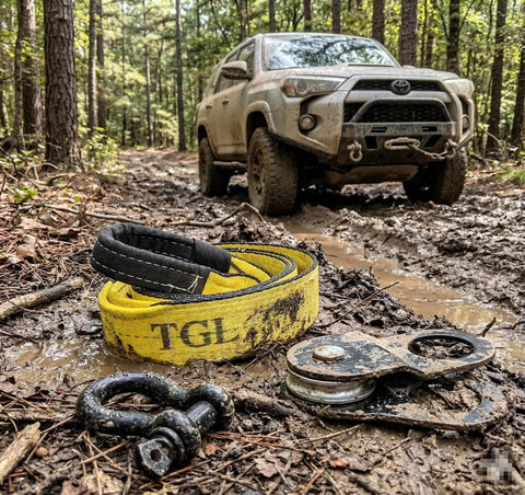 3 Inch Wide 8 Foot Tree Saver Strap With Loops Heavy Duty Winch And Recovery Tow Strap 30000 Lbs MBS in muddy forest with Jeep