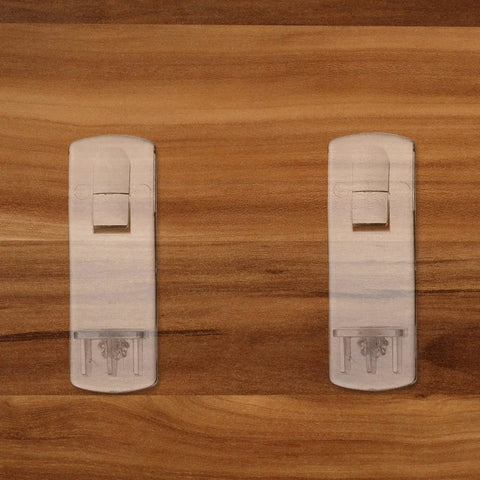 Close-up of 25 Piece Plastic Locking Shelf Pegs for Kitchen Cabinets and Furniture, shown on a wood surface for easy installation.