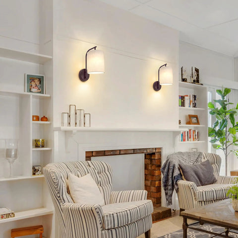 MATAMEYE Battery Operated Wall Sconce Set of 2, Dark Chocolate Wall Light mounted on a wall beside cozy armchairs in a living room.