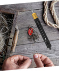 KICHOUSE stainless steel fishing hook detacher tool, black handle with yellow grip, near lures.