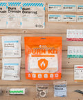 Front view of Rhino Rescue orange Burn Kit pouch with 4x4 burn dressings, gel packets, burn pads, gloves, tape, scissors.