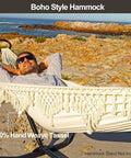Man relaxing in Chill Boho Macrame Hammock with tassels, soft cotton blend, portable patio backyard porch lounger, 300 lbs capacity.