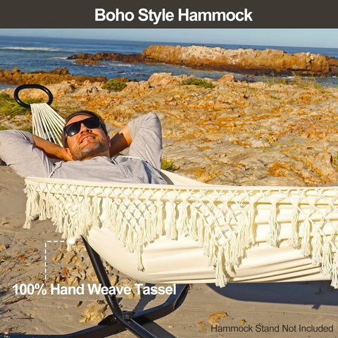 Man relaxing in Chill Boho Macrame Hammock with tassels, soft cotton blend, portable patio backyard porch lounger, 300 lbs capacity.