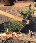 All Purpose Garden Pick Mattock Hoe With Wooden Handle 15.7 Inch Forged Adze Pick in action, chopping a tree branch