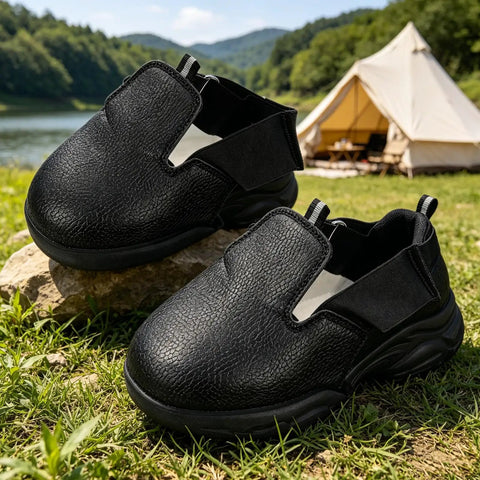 Heavy Duty Steel Toe Shoe Covers With Adjustable Strap Safety Overshoes For Work on rocks, black breathable fabric, outdoor setting.