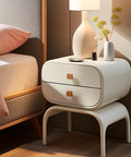 Stylish nightstand with modern design, featuring drawers and decorative items, perfect for bedroom use.