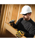 Worker wearing Polarized Safety Glasses With Z87.1 Rating Built For Grind-Ready Outdoor Work On The Job Site using a drill.