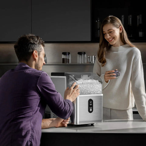 Top Tier Nugget Ice Maker Producing Thirty Three Pounds Daily Of Crisp Chewable Crushed Ice With Easy Self Cleaning Setup and Clear Viewing Window being used by a couple in a modern kitchen.
