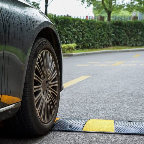 Car wheel on Beefy Heavy Duty 2 Pack 2 Channel Modular Rubber Driveway Speed Bumps And Cable Protector Ramp on road