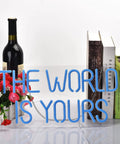 17 By 8 Inch LED Neon Blue The World Is Yours Dimmable Wall Sign with USB Power, shown beside books and flowers