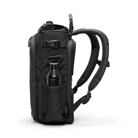 Side view of City Commuter Camera Backpack with 18 Liter Rolltop Closure, showing padded straps and water bottle pocket in rugged black.