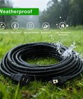Heavy Duty Waterproof Extension Cord With A Badass 100 Ft Black Flat Cable and Standard Two Prong Plugs on wet grass.