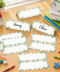 48 Pcs Tented Desk Nameplates Set For Students, 9 By 3 Inch Eucalyptus Style Reusable Name Tags on a classroom desk with crayons