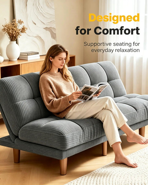 Woman sitting on 65 Inch Convertible Futon Sofa Bed With Adjustable Backrest Corduroy Grey Upholstery, reading a book.
