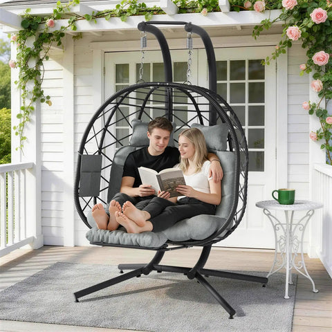 Cozy Double Hanging Egg Chair For Two With Adjustable Footrest And Stand, indoor outdoor wicker swing with cushions on a patio, grey.