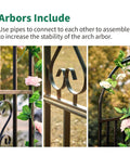 Close-up of a Sturdy Black Wrought Iron Pergola Arbor Garden Arch With Ground Spikes showing decorative scrollwork design and climbing plants