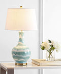 Green And White Striped Ceramic Table Lamp For Bedroom And Living Room Coastal Modern Bedside Light With Gold Base And White Linen Shade LED Bulb Included Measures 30.5 Inches Tall on table with books and flowers